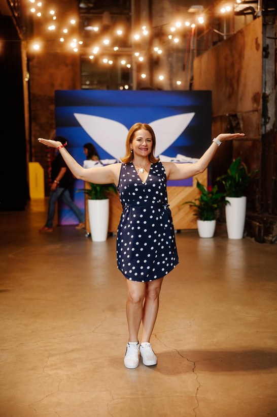Francesca Facio standing with arms open in front of wings